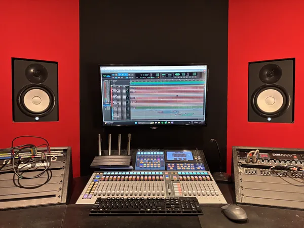 Mesa de som e monitores de estúdio na sala técnica